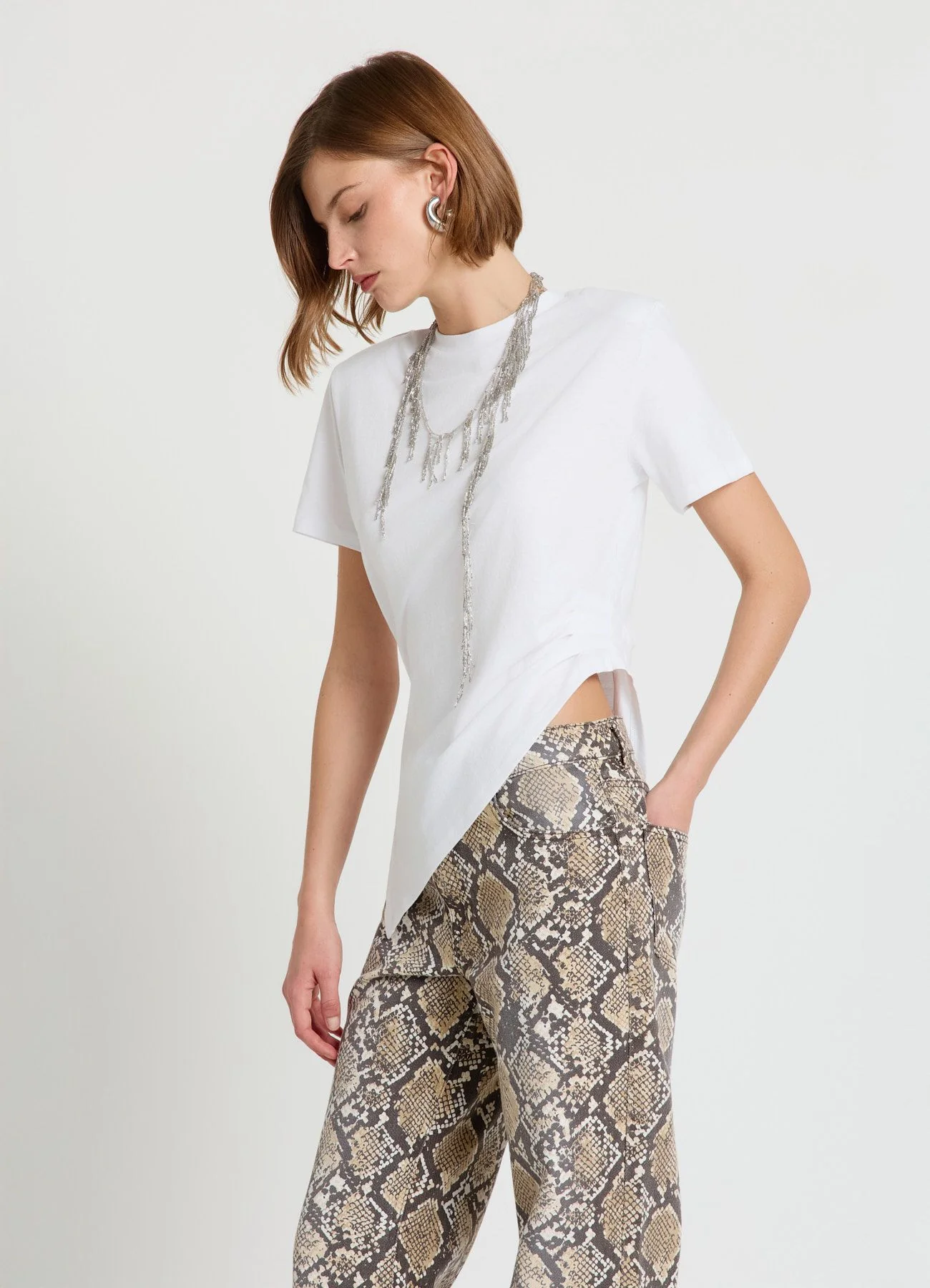 T-shirt con arriccio laterale e fondo asimmetrico