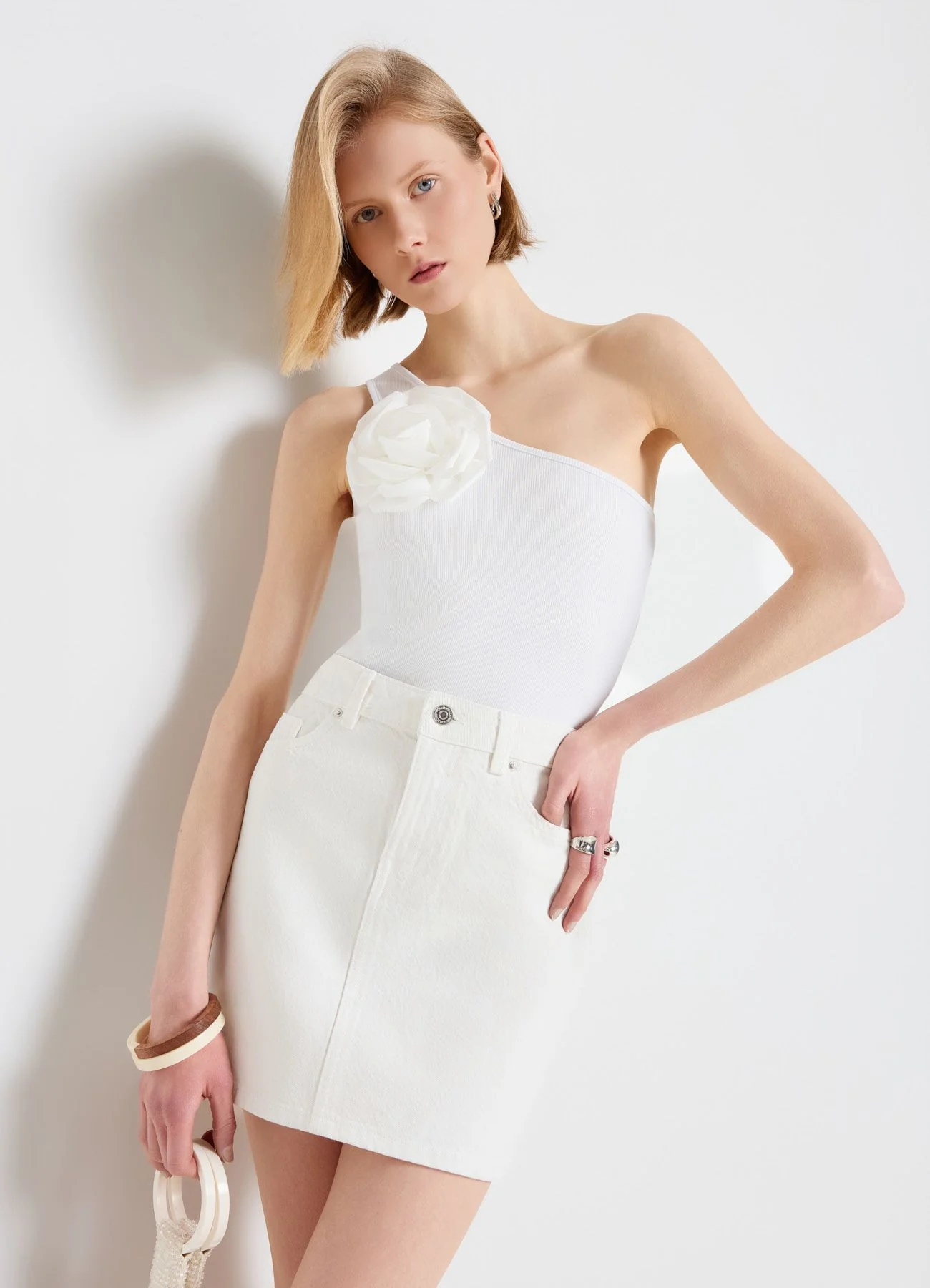 Top monospalla con fiore